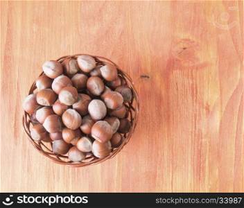 Hazelnuts in a basket on a wooden table. Basket with hazelnuts top View