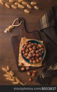Hazelnuts in a ceramic bowl on a rustic kitchen countertop