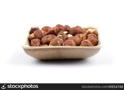 Hazelnuts in bamboo bowl on white