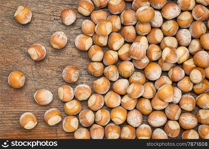 hazelnuts in shells over grunge weathered wood surface