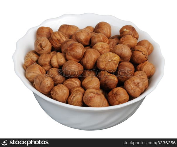 Hazelnuts on a white plate on a white background, isolated.