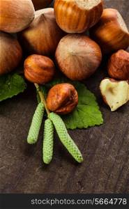 Hazelnuts with shell and green leaf on the wooden table