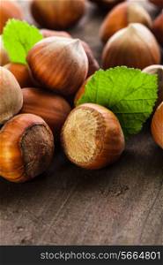Hazelnuts with shell and green leaf on the wooden table