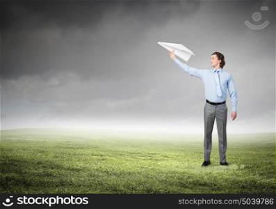 He doesn&rsquo;t take life too seriously. Young businessman outdoor with paper plane in hand