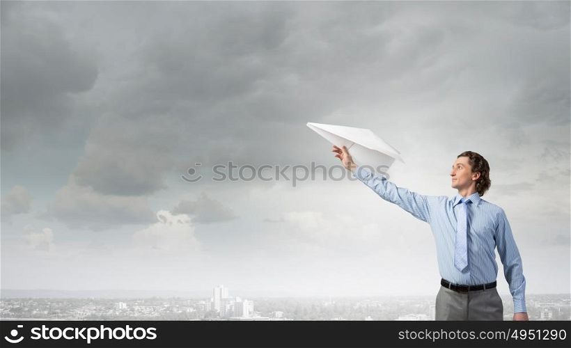 He doesn&rsquo;t take life too seriously. Young businessman with paper plane in hand