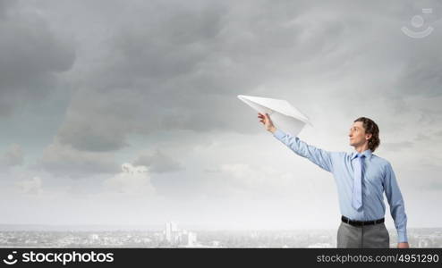 He doesn&rsquo;t take life too seriously. Young businessman with paper plane in hand