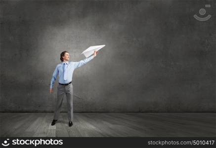 He doesn&rsquo;t take life too seriously. Young businessman with paper plane in hand