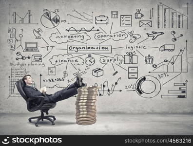 He has big plan for big income. Young confident businessman sitting in chair with legs on stack of coins