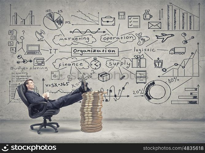 He has big plan for big income. Young confident businessman sitting in chair with legs on stack of coins