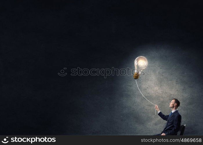 He has good idea. Businessman with bulb on rope representing bright idea