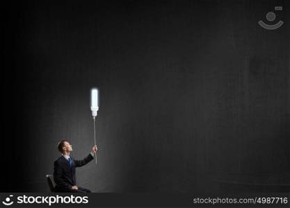 He has good idea. Businessman with bulb on rope representing bright idea