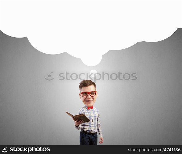 He has great mind. Young funny big headed man in glasses with book in hands