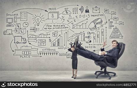 He heaps tasks on her delicate shoulders. Young businessman sitting in chair with legs on colleagues shoulders