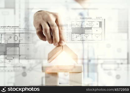 He is building his business. Close view of businessman making pyramid with empty wooden cubes