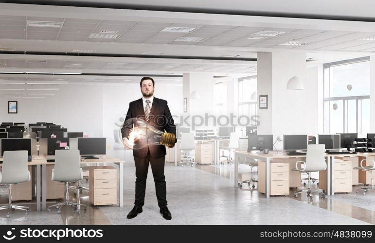 He is carrying out an idea. Elegant businessman in modern office with huge bulb in hands