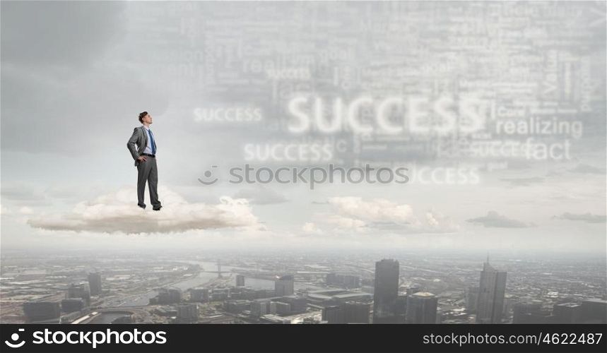 He is confident in his success. Confident businessman with arms on waist standing on cloud