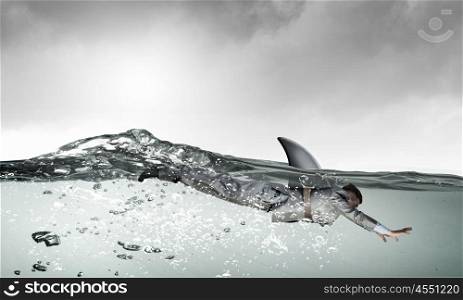 He is dangerous like shark. Young businessman with shark flipper swiming under water