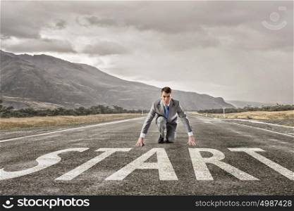 He is determined to start now. Young businessman on road ready to run race