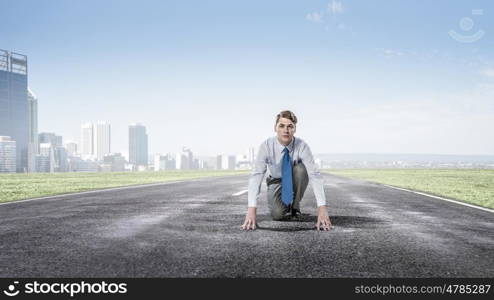 He is determined to win. Young businessman standing in start position ready to compete