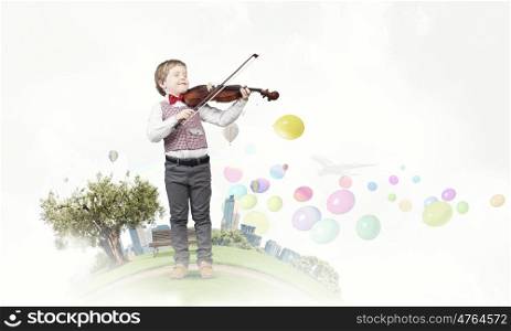 He is little talent. Adorable boy wearing red bowtie and playing violin
