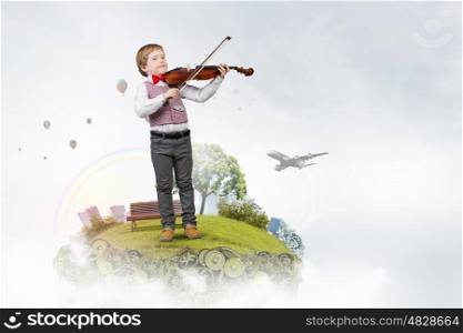 He is little talent. Adorable boy wearing red bowtie and playing violin
