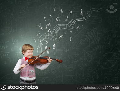 He is little talent. Adorable boy wearing red bowtie and playing violin