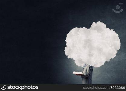 He is up in the clouds. Young businessman with book in hands and cloud instead of head