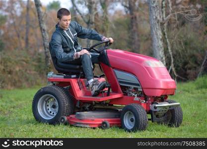 he is using a ride-on mower