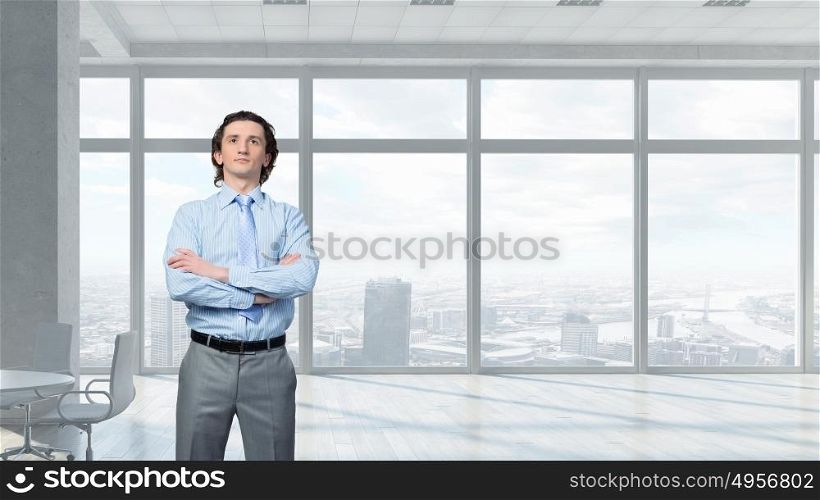 He is young professional mixed media. Young confident businessman with arms crossed on chest