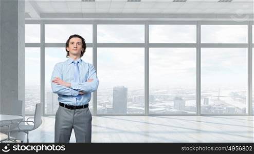He is young professional mixed media. Young confident businessman with arms crossed on chest