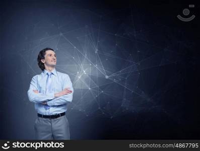 He is young professional. Young confident businessman with arms crossed on chest against connection concept background