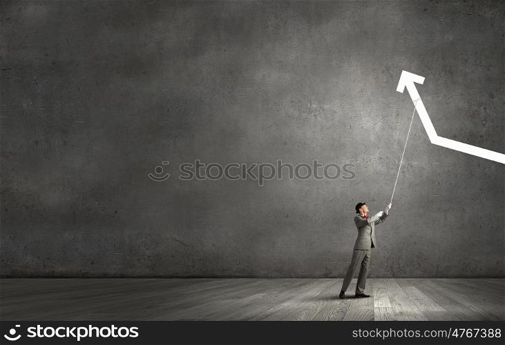 He makes it rise. Businessman pulling arrow with rope and making it raise up
