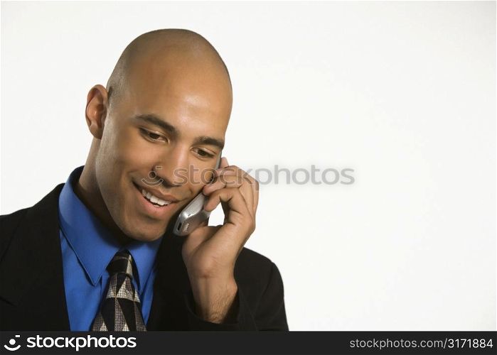 Head and shoulder portrait of African American man in suit talking on cellphone.