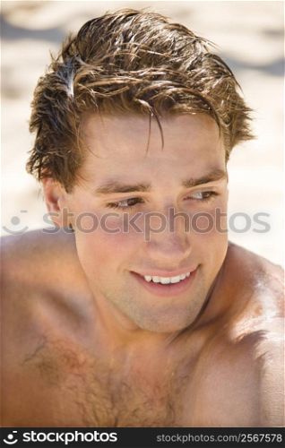 Head and shoulder portrait of handsome man on beach.