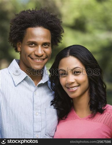 Head and shoulder portrait of smiling couple in park.