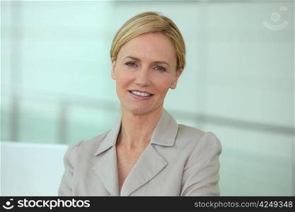 Head and shoulders of a smiling businesswoman in a biege suit