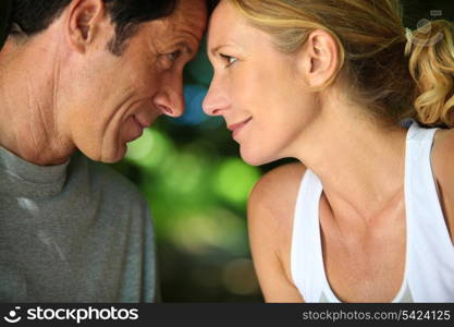 Head and shoulders of mature romantic couple looking at each other