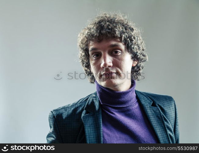 Head and shoulders portrait of a young caucasian guy with curly hair