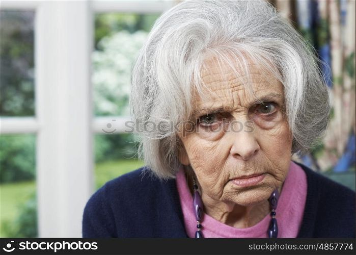 Head And Shoulders Portrait Of Angry Senior Woman At Home
