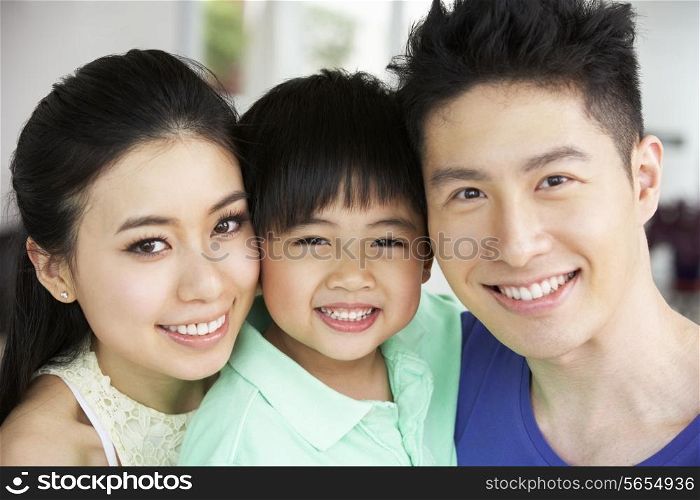 Head And Shoulders Portrait Of Chinese Family Together At Home