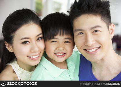 Head And Shoulders Portrait Of Chinese Family Together At Home