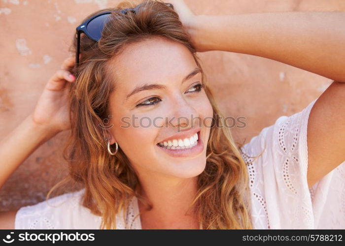 Head And Shoulders Portrait Of Pretty Woman Against Wall