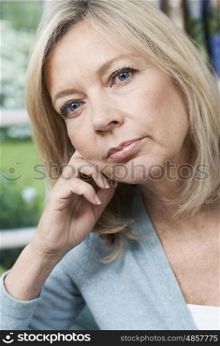 Head And Shoulders Portrait Of Thoughtful Mature Woman At Home