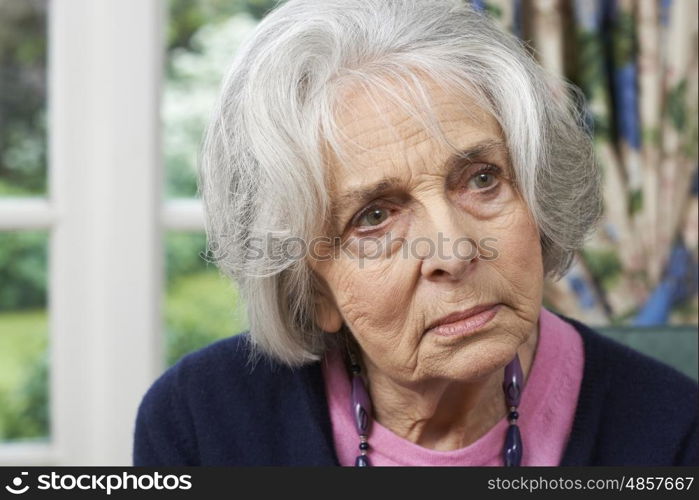 Head And Shoulders Portrait Of Thoughtful Senior Woman At Home