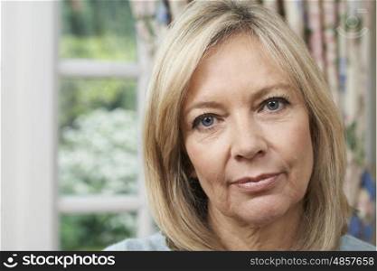 Head And Shoulders Portrait Of Unhappy Mature Woman At Home