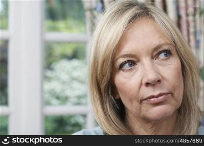 Head And Shoulders Portrait Of Unhappy Mature Woman At Home
