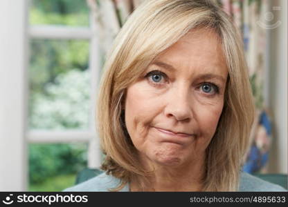 Head And Shoulders Portrait Of Unhappy Mature Woman At Home