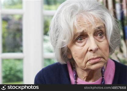 Head And Shoulders Portrait Of Unhappy Senior Woman At Home