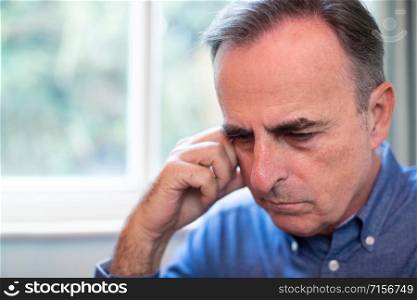 Head And Shoulders Shot Of Mature Man Suffering With Depression At Home