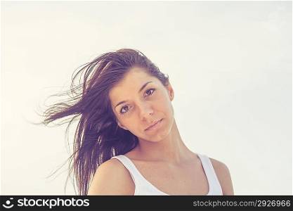 head and shoulders shot of the brunette against sky, outdoor, vintage look toned image